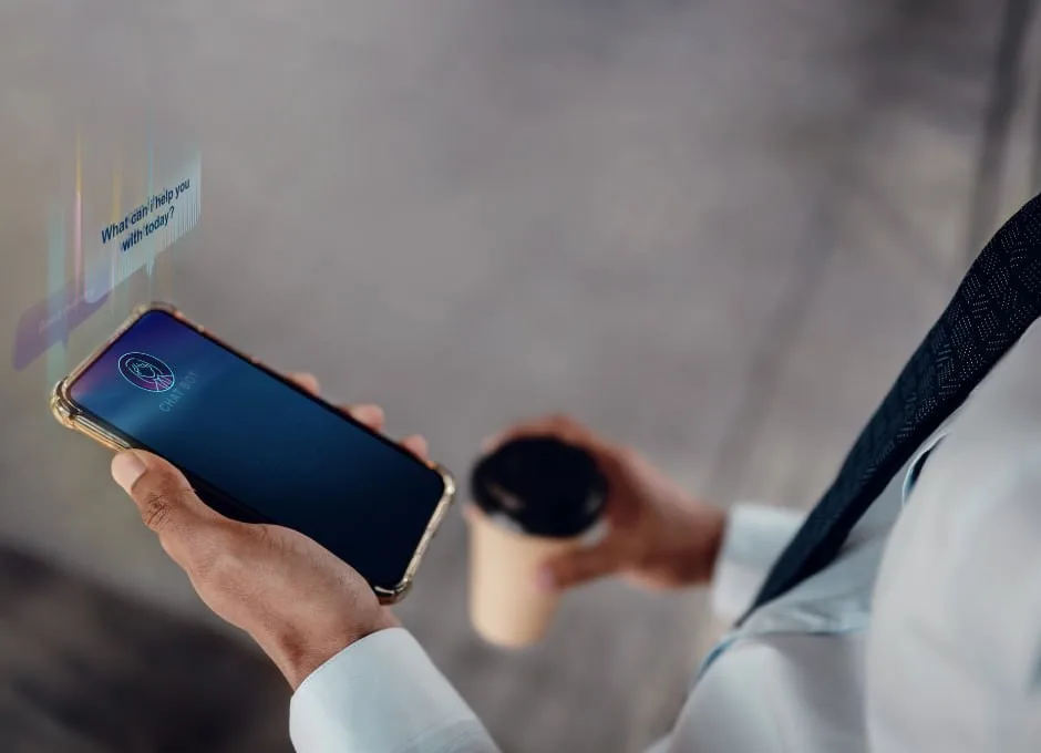 Person in a white shirt holding a coffee cup and a smartphone.
